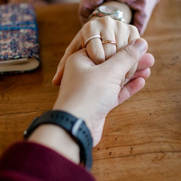 Close-up of a couple's hands intertwined during a partner yoga session.